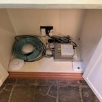 WiFi routers and cables inside a cupboard by Mech-Elec Group Ltd