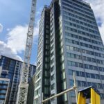 tall block of flats being built alongisde crane